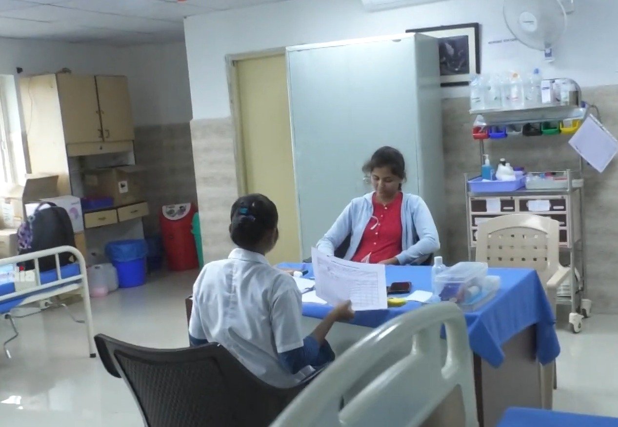 Doctor consulting a patient under canopy at health drive